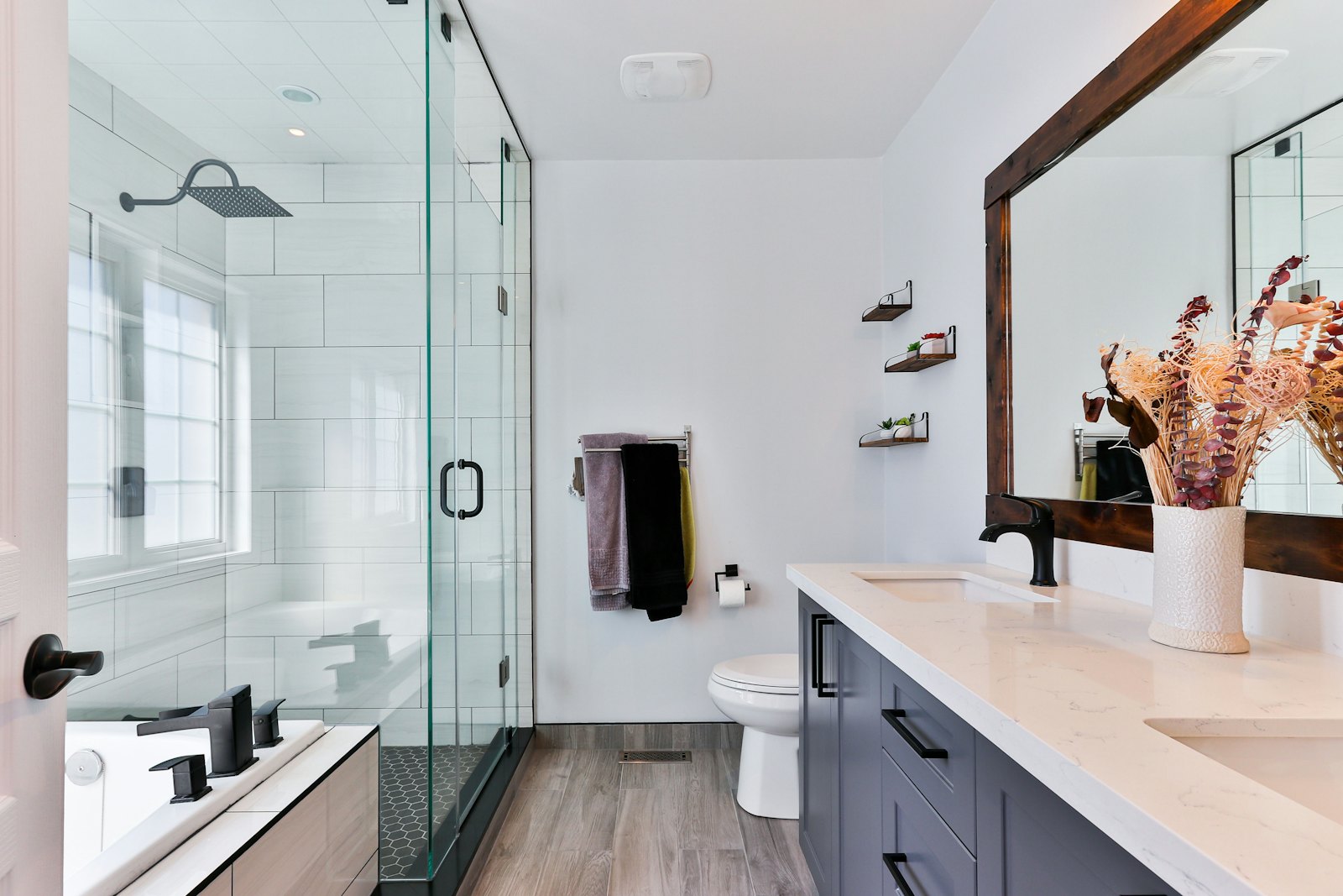 Salle de bains impeccable avec paroi de douche en verre et grand miroir
